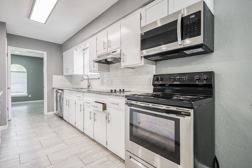 1810 Marlin Street Portland, TX 78374 - Photo 13 of 32 a kitchen with stainless steel appliances granite countertop white cabinets and a stove top oven