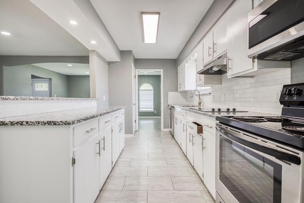 1810 Marlin Street Portland, TX 78374 - Photo 14 of 32 a large kitchen with stainless steel appliances granite countertop a stove and a sink