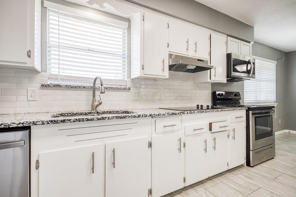 1810 Marlin Street Portland, TX 78374 - Photo 16 of 32 a kitchen with stainless steel appliances granite countertop white cabinets a sink a stove a window and white appliances