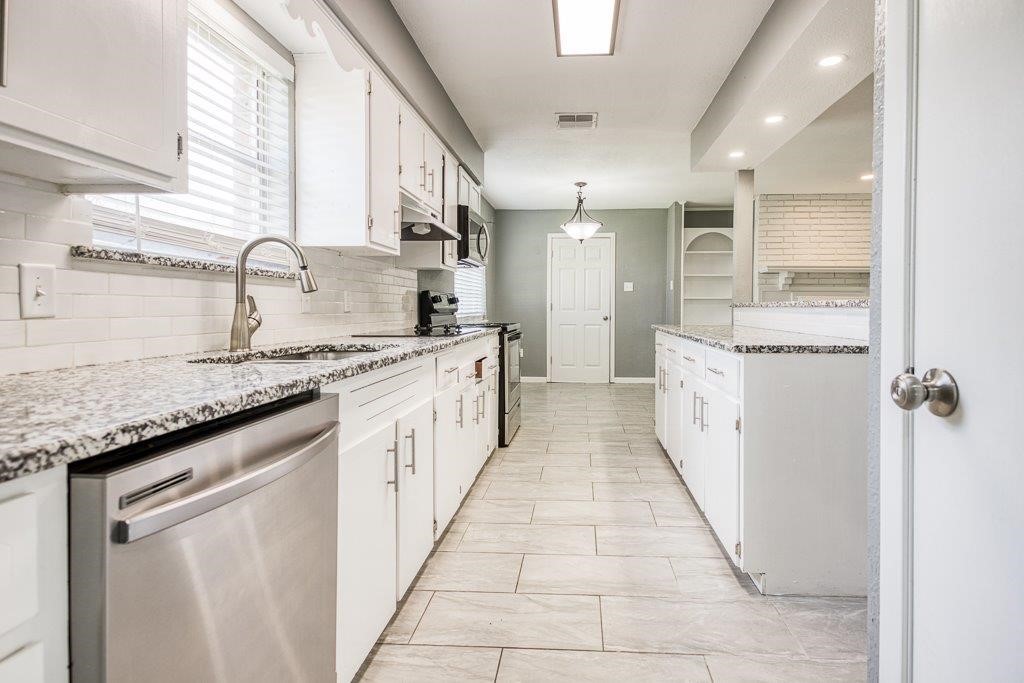 1810 Marlin Street Portland, TX 78374 - Photo 18 of 32 a large kitchen with granite countertop a sink and cabinets