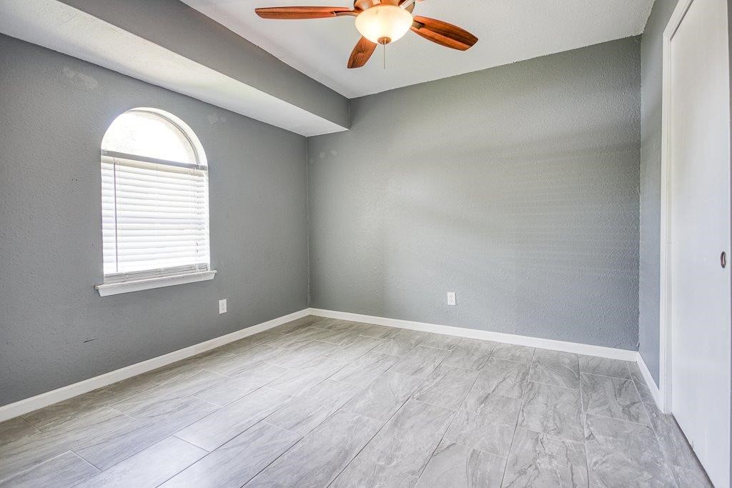 1810 Marlin Street Portland, TX 78374 - Photo 19 of 32 an empty room with windows and chandelier fan