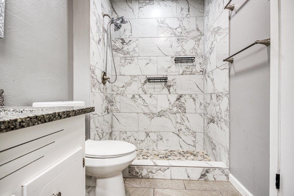 1810 Marlin Street Portland, TX 78374 - Photo 25 of 32 a bathroom with a granite countertop toilet and a shower