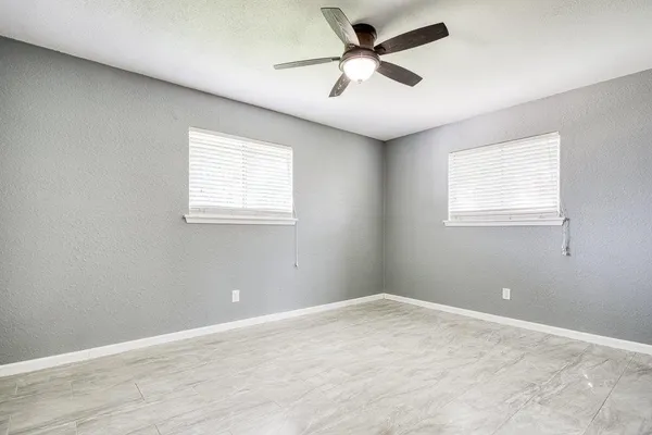 an empty room with fan and entryway