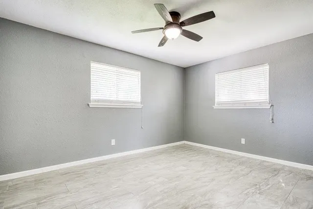 an empty room with fan and entryway