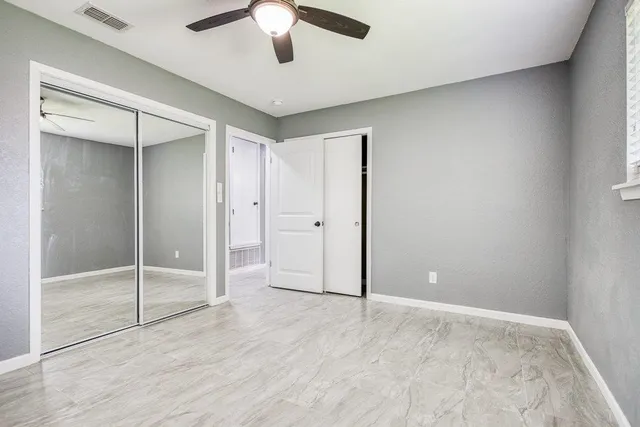 a bathroom with a granite countertop sink a toilet and a shower