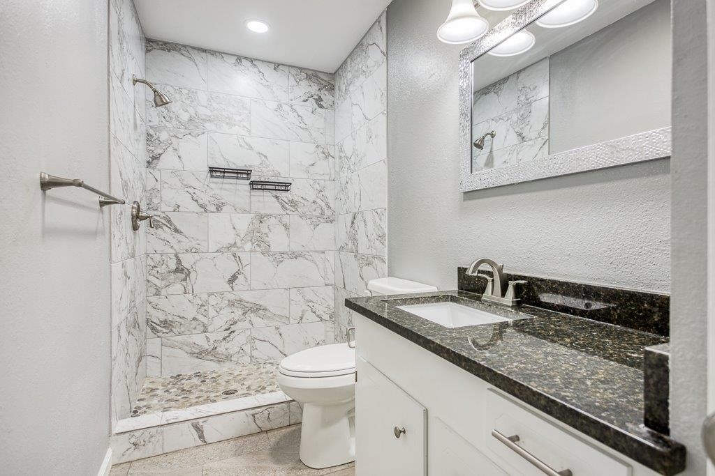 1810 Marlin Street Portland, TX 78374 - Photo 29 of 32 a bathroom with a granite countertop sink a toilet and a shower