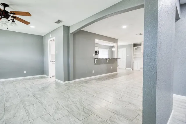 a view of a room with a chandelier fan and windows