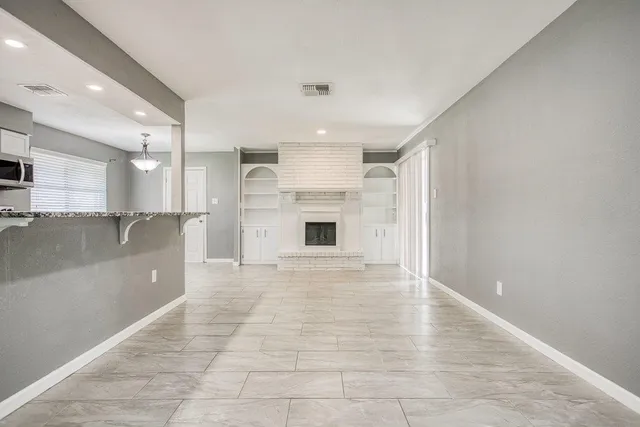 a view of a livingroom with a fireplace and cabinet
