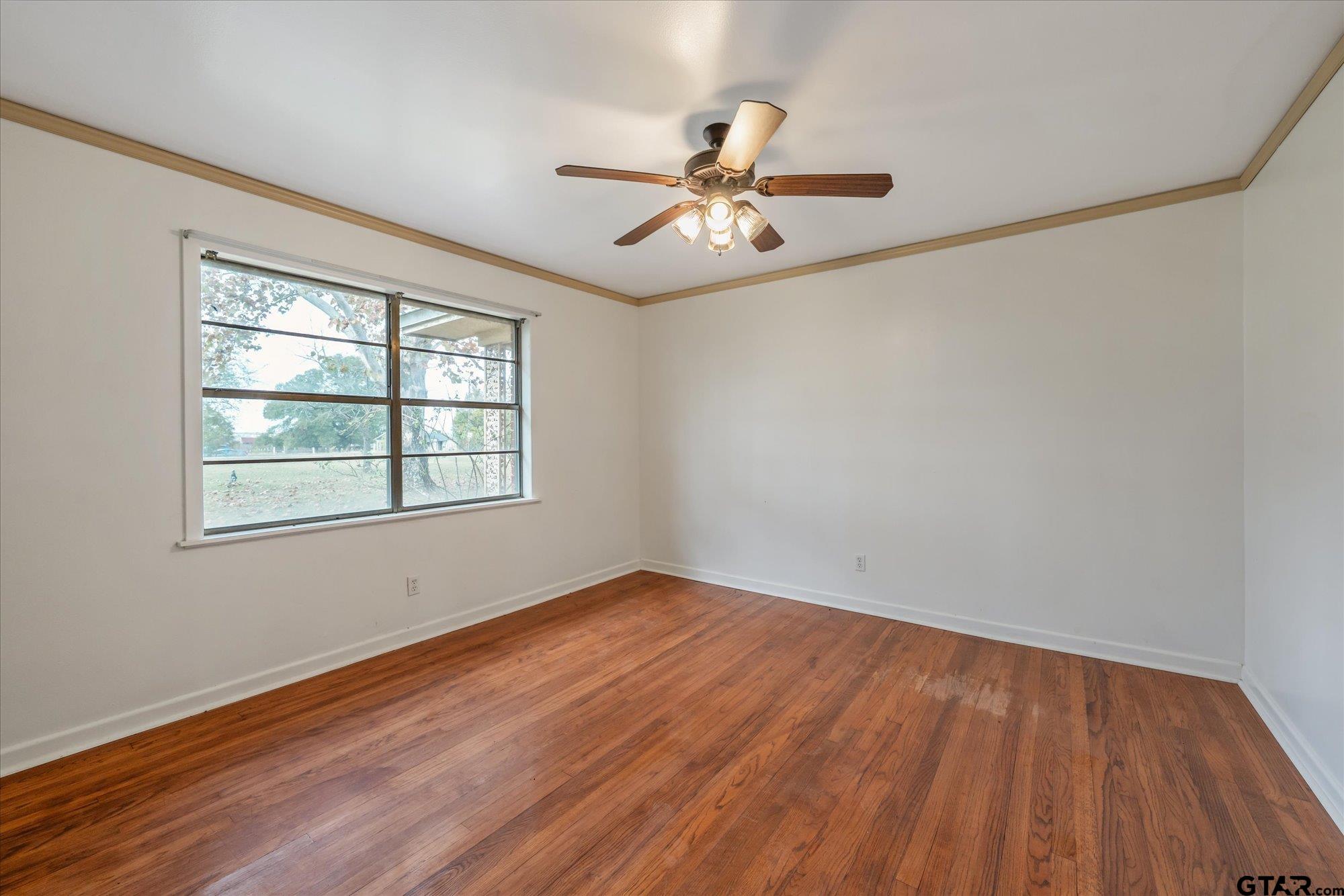 11619 County Road 4331 Larue, TX 75770 - Photo 17 of 30 an empty room with wooden floor fan and windows