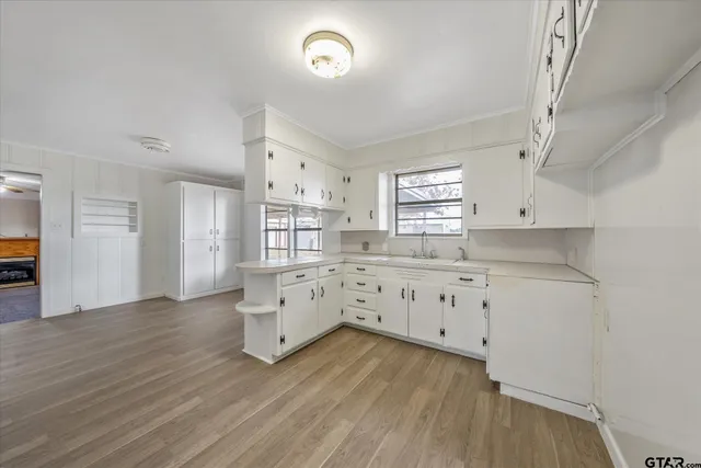 a kitchen with cabinets wooden floor and a fireplace
