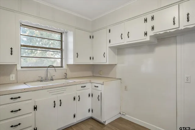 a kitchen with cabinets appliances a sink and a window