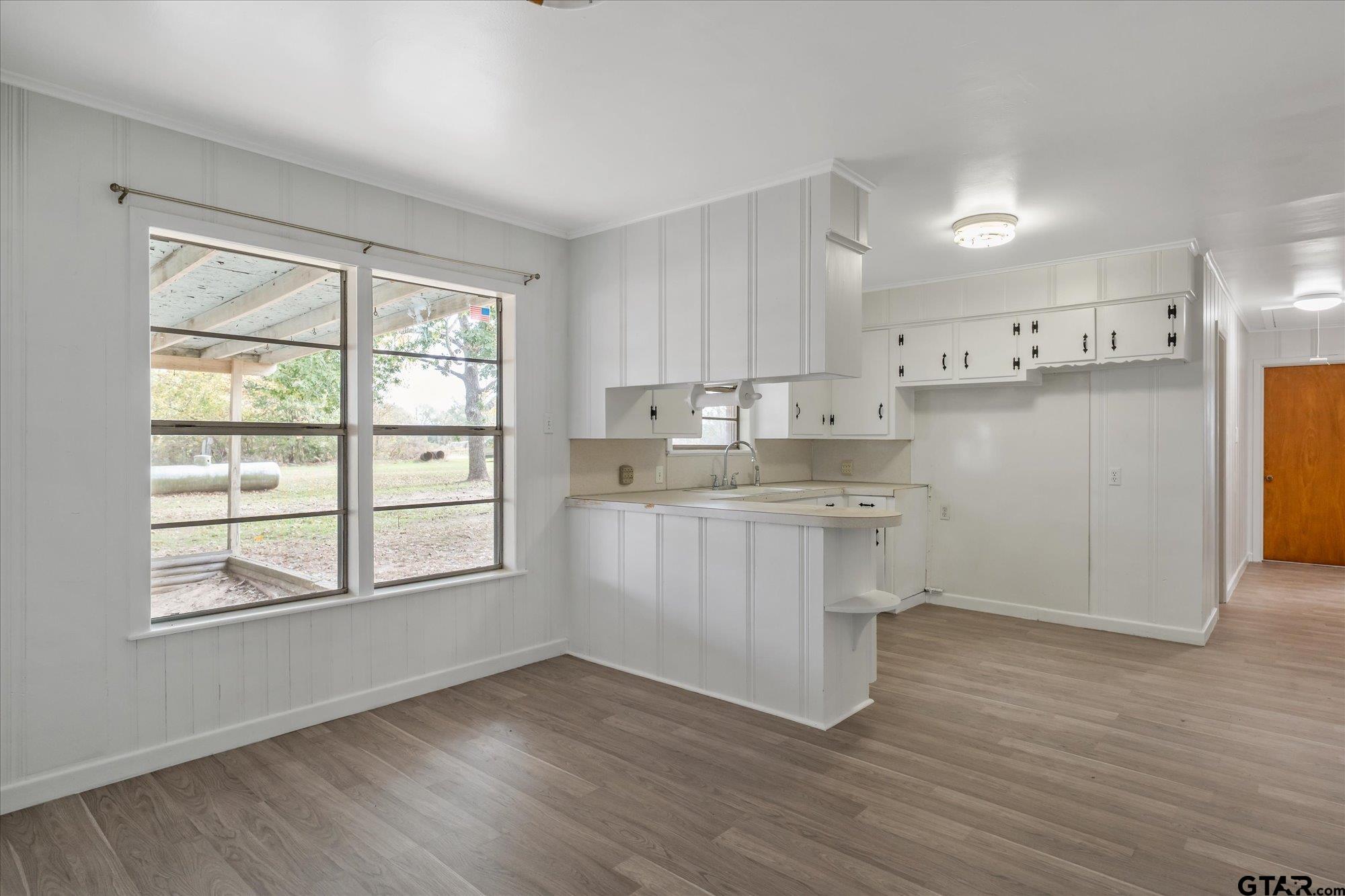 11619 County Road 4331 Larue, TX 75770 - Photo 7 of 30 a kitchen with wooden floors and white cabinets