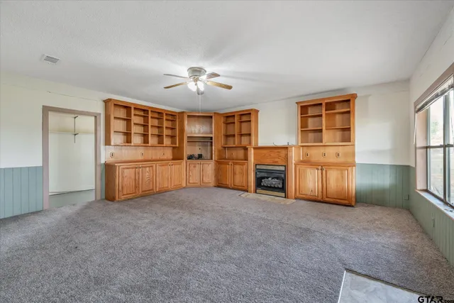 an empty room with closet and windows