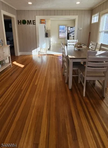 a room with wooden floor table and chairs