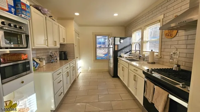 a large kitchen with stainless steel appliances granite countertop a stove and a sink