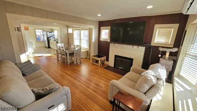 a living room with furniture a fireplace a flat screen tv and windows