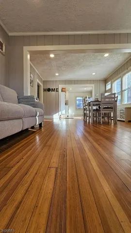 a living room with stainless steel appliances furniture and wooden floor