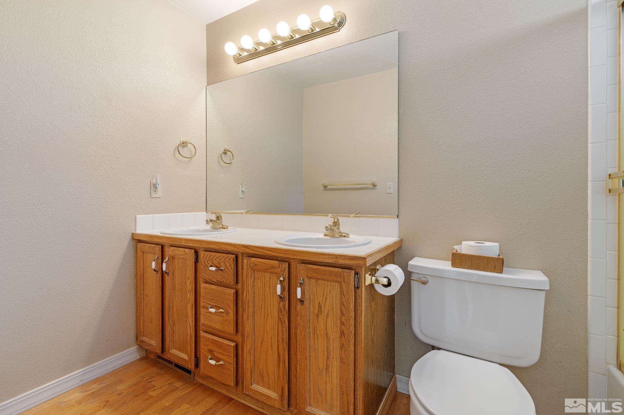 571 Citadel Road Reno, NV 89503 - Photo 28 of 38 a bathroom with a granite countertop toilet sink and mirror