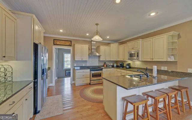 a kitchen with stainless steel appliances granite countertop a stove refrigerator sink and cabinets