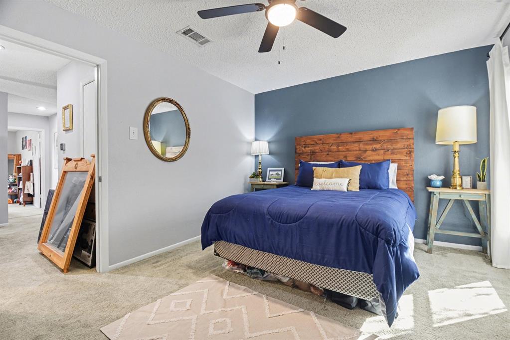 9446 Chimney Corner Dallas, TX 75243 - Photo 10 of 15 a bedroom with a large bed and a chandelier