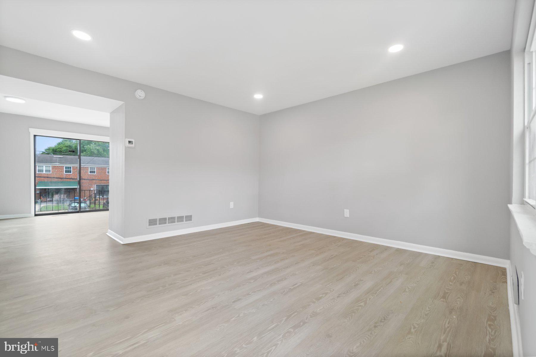 653 Charraway Road Baltimore, MD 21229 - Photo 5 of 27 a view of an empty room with wooden floor and a window