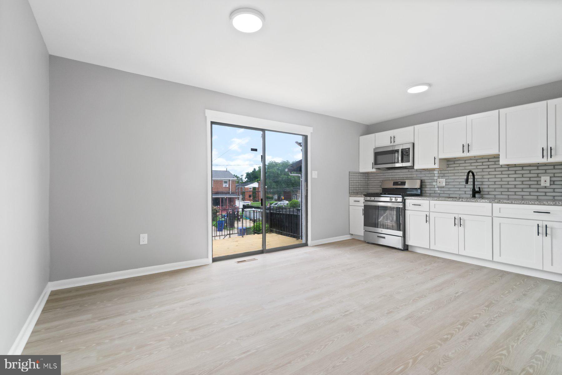 653 Charraway Road Baltimore, MD 21229 - Photo 8 of 27 a view of kitchen with stainless steel appliances granite countertop a stove top oven a sink with dishwasher and cabinets