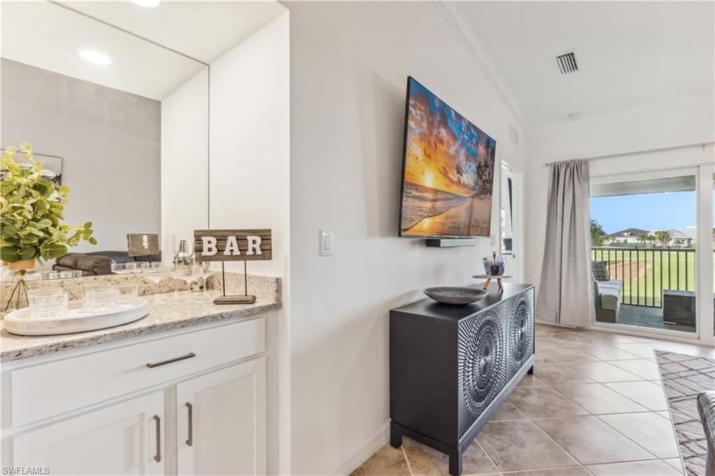 43051 Greenway Boulevard, Unit 822 Babcock Ranch, FL 33982 - Photo 6 of 16 a kitchen with stainless steel appliances granite countertop a stove a sink and a microwave