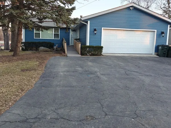 a view of a house with a yard and large tree