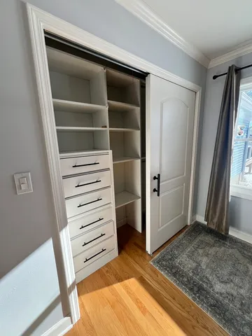 a view of walk in closet with empty racks
