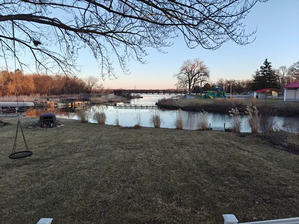 a view of a lake with a bench under an umbrella