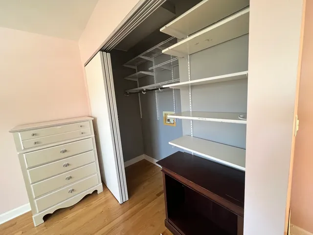 a view of walk in closet with empty racks