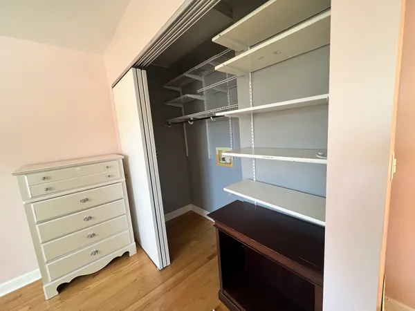 a view of walk in closet with empty racks