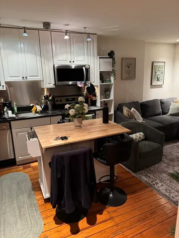 a kitchen with a sink cabinets and wooden floor