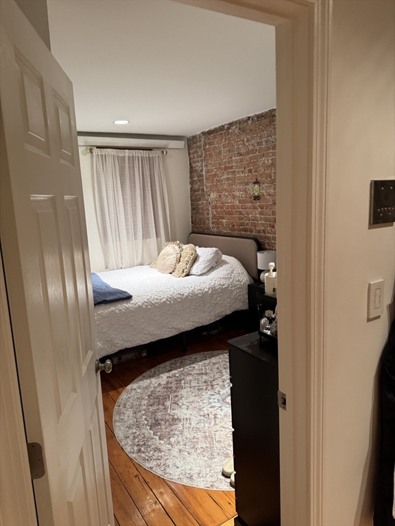 1914 Washington Street, Unit 4 Boston, MA 02118 - Photo 8 of 11 a bed sitting in a bedroom next to a wooden cabinet