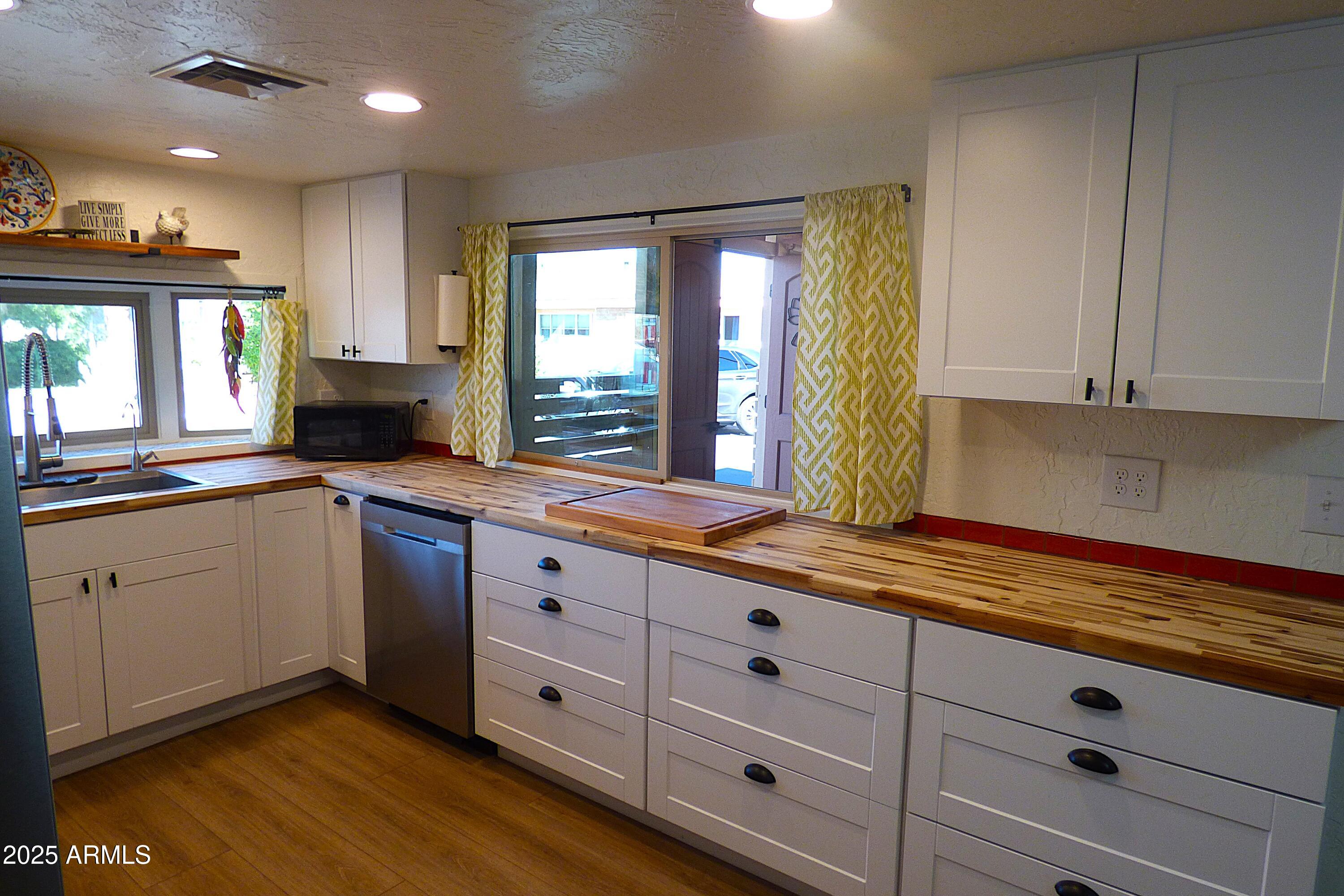 6700 East Thomas Road, Unit 34 Scottsdale, AZ 85251 - Photo 12 of 71 a kitchen with granite countertop white cabinets stainless steel appliances a sink and a large window