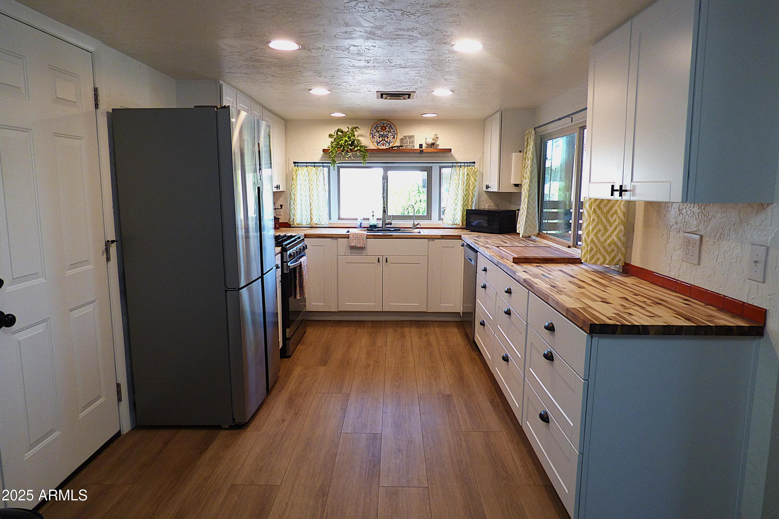 6700 East Thomas Road, Unit 34 Scottsdale, AZ 85251 - Photo 3 of 69 a kitchen with sink a refrigerator and wooden floor