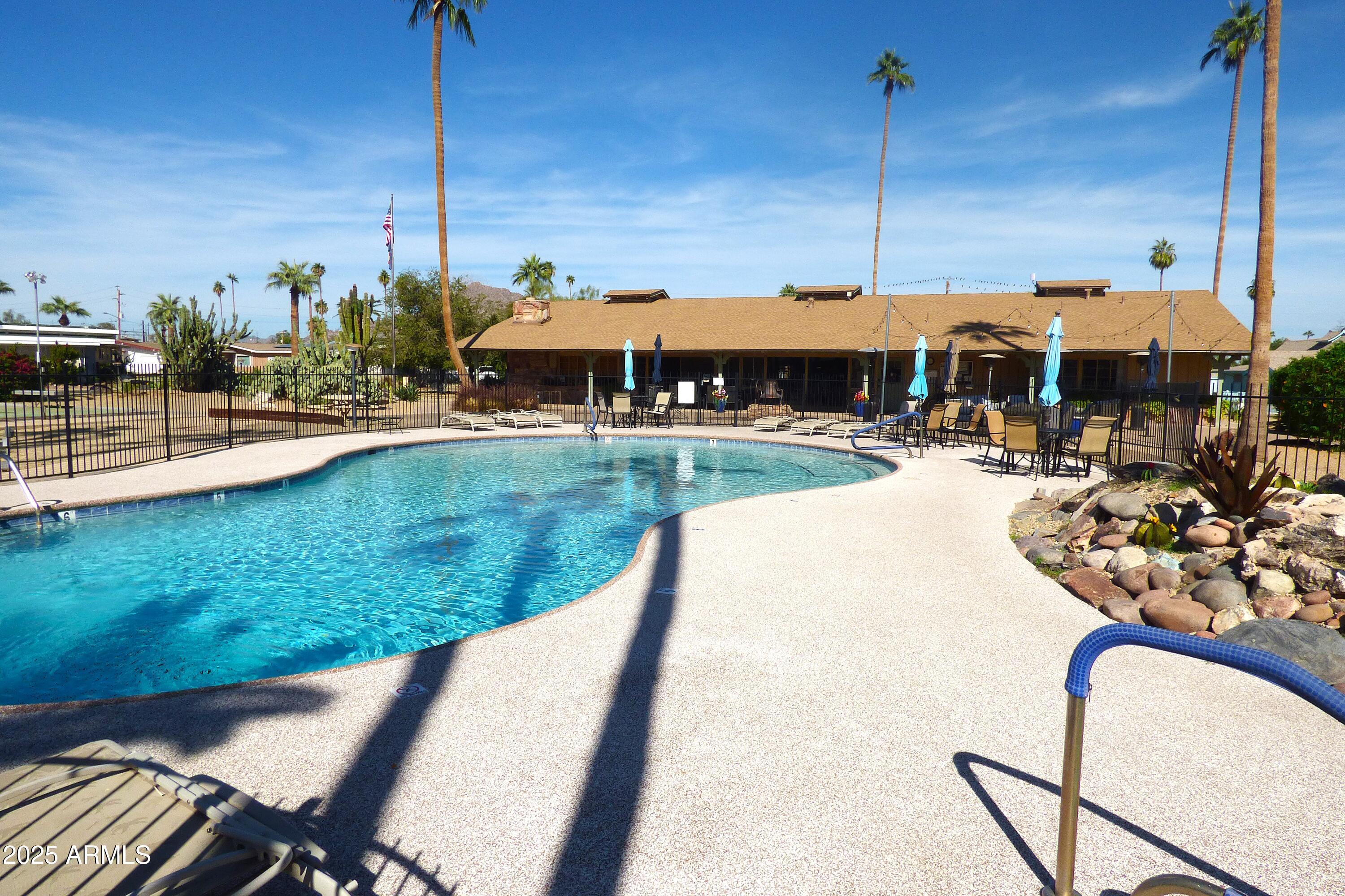 6700 East Thomas Road, Unit 34 Scottsdale, AZ 85251 - Photo 50 of 71 a view of a swimming pool with a table and chairs under an umbrella
