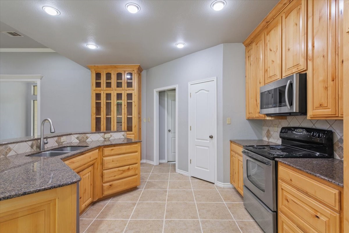 140 Oak Ridge Loop Whitney, TX 76692 - Photo 16 of 40 a kitchen with stainless steel appliances granite countertop a stove a sink and a microwave