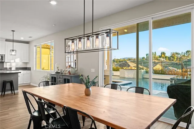 a kitchen with stainless steel appliances granite countertop a kitchen island a stove and a dining table with wooden floor