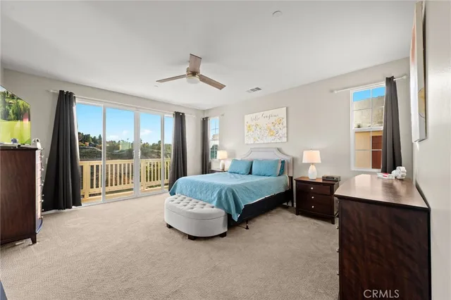 a bedroom with a bed and a flat tv screen next to a window