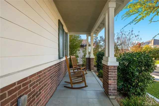 a view of a balcony with chairs and wooden fence