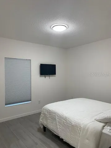 a bedroom with a bed and a flat screen tv