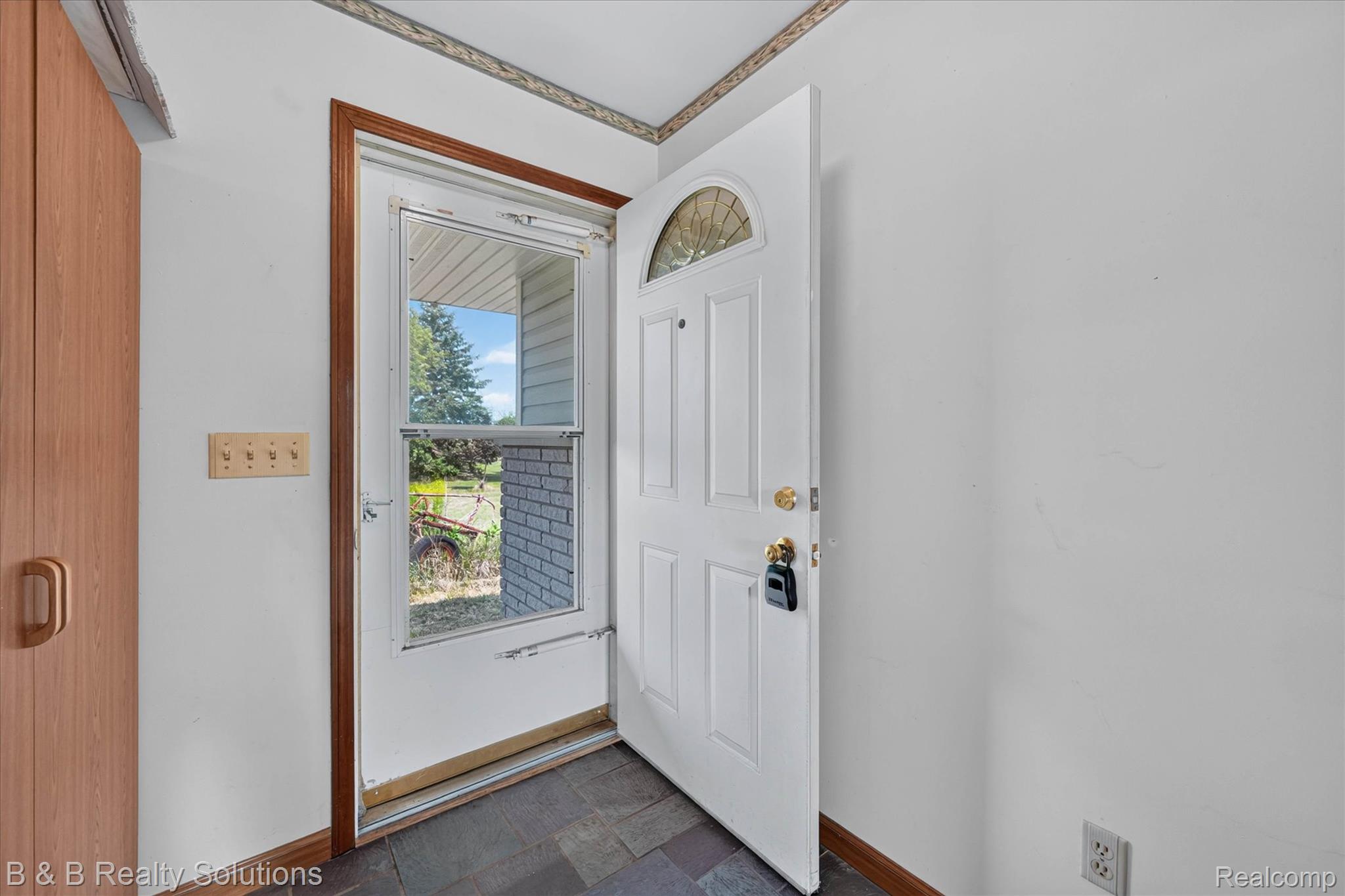 6605 Patrick Road North Branch, MI 48461 - Photo 5 of 44 Entryway featuring slate tile flooring and a light wood-finish built-in cabinet