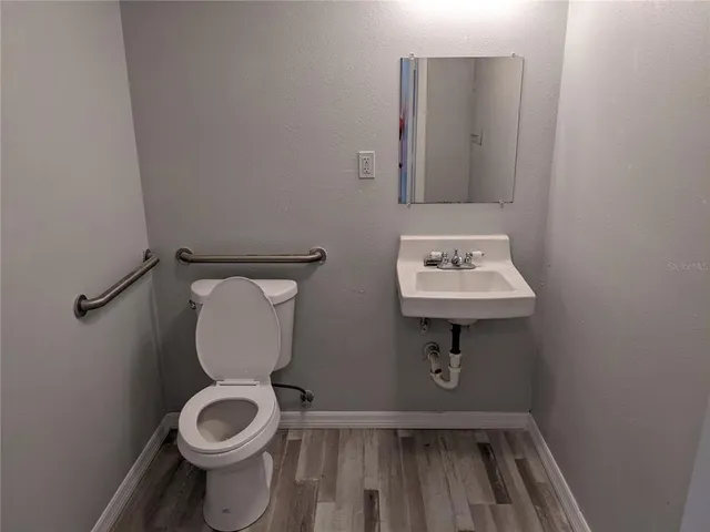 a bathroom with a toilet sink and mirror
