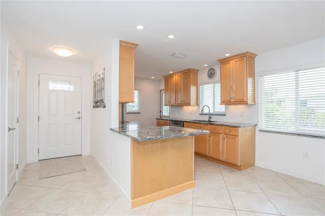 a kitchen with granite countertop a sink stove and refrigerator