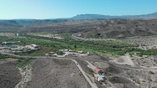 a view of a dirt road with large trees