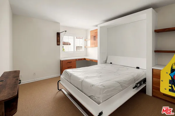 a bed sitting in a bedroom next to a window