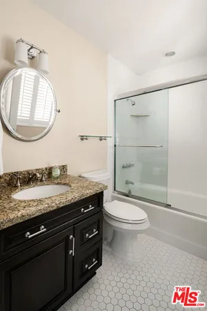 a bathroom with a granite countertop toilet sink and mirror