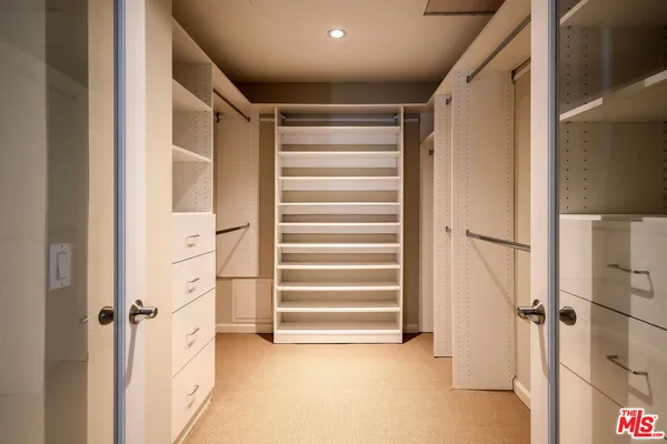 a view of walk in closet with empty racks