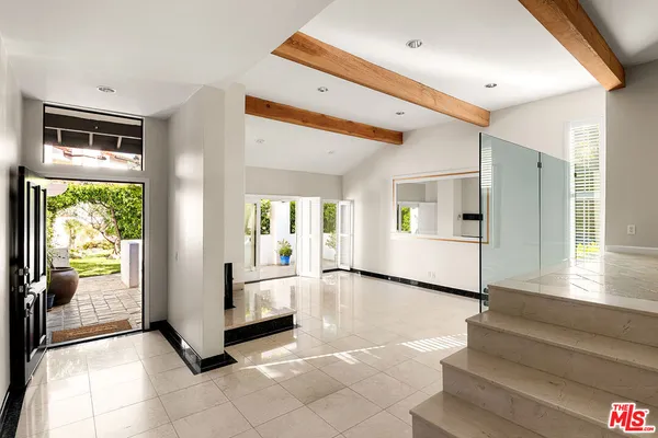 a view of an entryway with wooden floor and a livingroom